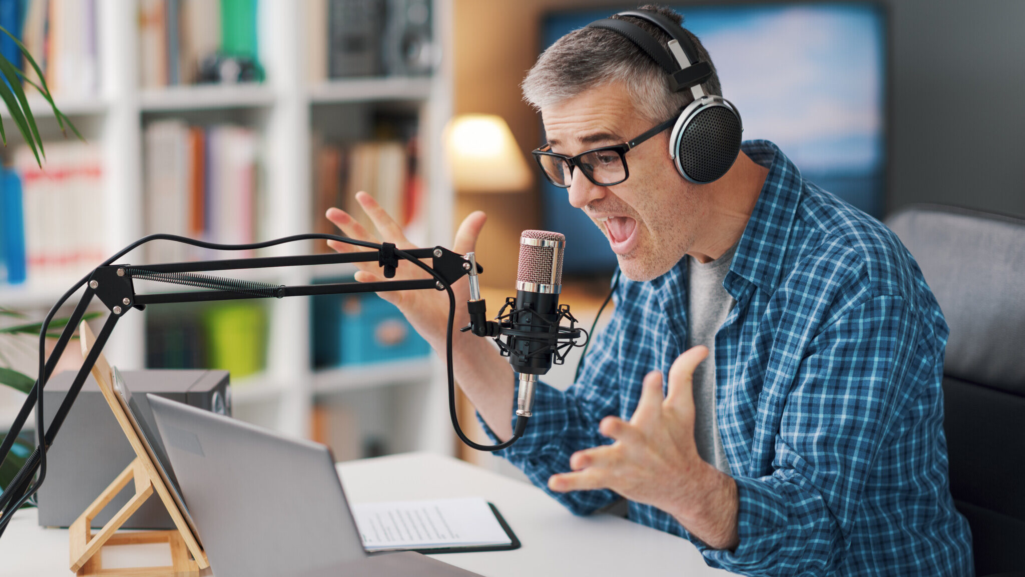 Shocked podcaster talking and staring at the laptop screen