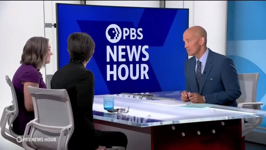 Three PBS News Hour anchors at a table