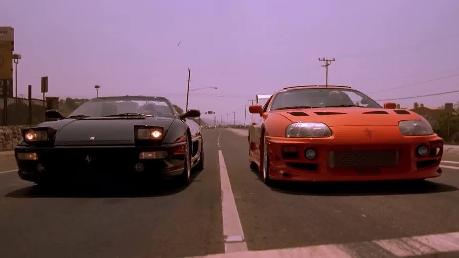 Two sports cars, one black, one red, on a highway