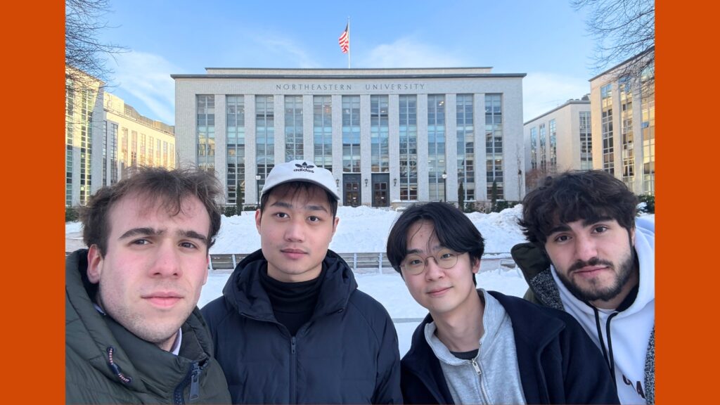 Four people in the snow in front of a building.