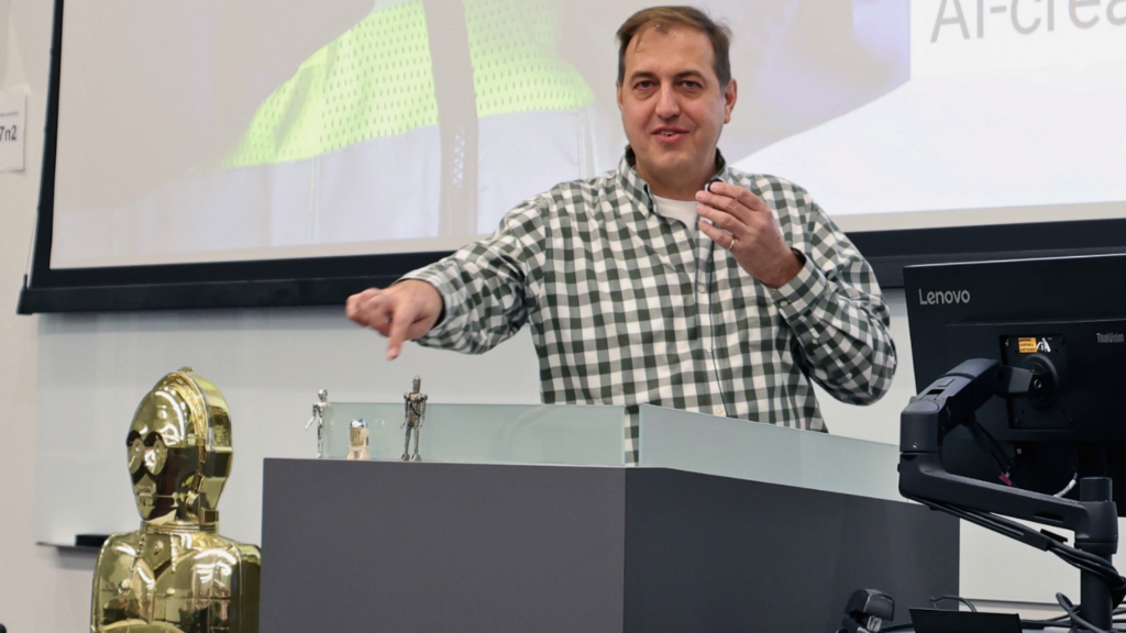 A person gesturing to toy figurines from Star Wars, including C-3PO and R2-D2.